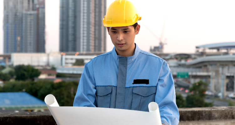 Foreman looking at blueprint at a construction site